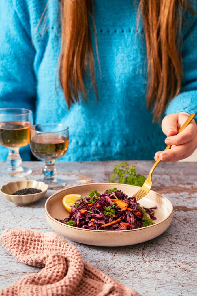 Eine Frau im blauen Pulli isst den Rotkohlsalat